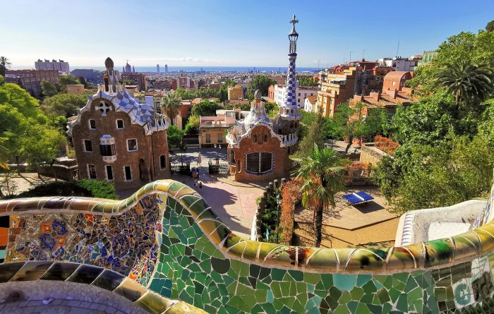 Banco de mosaico de trencadís y pabellones del Park Güell en Barcelona con vistas de la ciudad