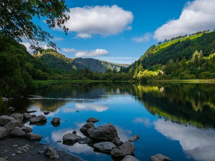 Glendalough lake and forested mountains in Wicklow Mountains National Park reflected in still water