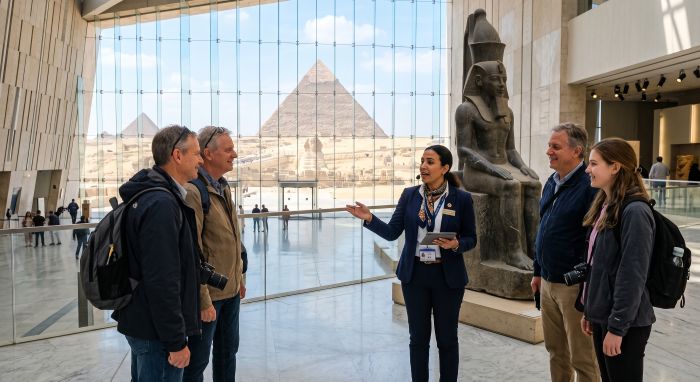 Private guide with a small group on the Grand Staircase of the Grand Egyptian Museum near the Giza pyramids (AI illustration)