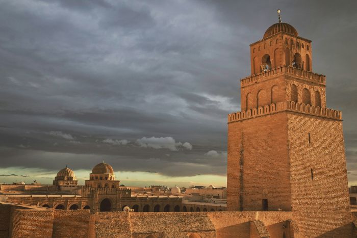 Guida e visitatori nel cortile della Grande Moschea di Kairouan durante un'escursione da Tunisi